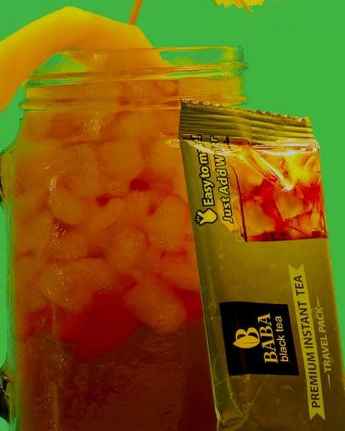 Iced mango tea in a mason jar next to a Baba travel pack